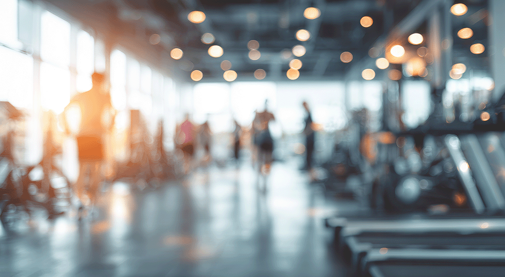 Geblurde moderne fitnessruimte met cardio- en krachtapparaten